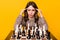 Photo of serious brunette lady sit look play chess hands head wear shirt isolated on vivid yellow color background
