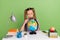 Photo of serious interested small schoolkid dressed striped uniform tails enlarging globe sitting desktop isolated green