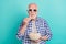 Photo of serious pensioner addicted to television eating popcorn wear checkered casual shirt isolated on teal color