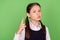 Photo of serious strict school girl dressed formal clothes pointing finger  green color background