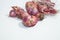 Photo of several red onions on a white background with a portrait photo angle