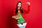 Photo of shiny exciting young woman dressed ugly pullover smiling holding christmas decorations  red color