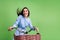 Photo of shiny funny young lady wear dotted clothes smiling driving bicycle looking empty space isolated green color
