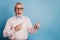 Photo of shocked aged guy directing fingers empty space blue background