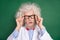 Photo of shocked amazed crazy mad old scientist in glasses see unbelievable information isolated on green color