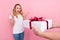 Photo of shocked astonished young woman receive gift good mood holiday isolated on pink color background
