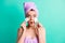 Photo of shocked girl hold two cotton disc open mouth wear violet towel turban isolated teal color background