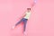 Photo of shocked girl stand one leg hold flying balloon wear green t-shirt jeans sneakers isolated on pink background