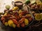 The photo shows a beautiful still life. Boiled crayfish and corn are in a deep black bowl. Many different ingredients - lemon,