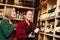 Photo on side of two women with bottle of wine in store on background of shelves