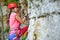 Photo of side view of young sports woman in red helmet climbing up mountain
