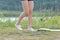 Photo slender legs of girl in shorts and sneakers in woods near