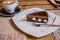 Photo of slice of chocolate cake with filling on a white plate with a fork