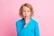 Photo of small funny child cover lips finger staring wear blue turtleneck  pastel pink color background