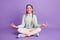 Photo of small peaceful lady sit floor lotus pose wear green sweater pants shoes  violet background