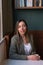 Photo of a smiling entrepreneurial woman sitting in a coffee shop