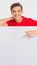 Photo of smiling  Handsome white guy pointing on  advertising big board. Portrait of happy young man pointing buy finger to the