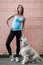 Photo of sports girl with labrador at building wall