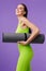Photo of sporty happy woman holding yoga mat and smiling