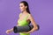 Photo of sporty serious woman holding yoga mat and looking forward