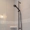 Photo Square Black shower fixtures of a bathroom with white tile wall and clear glass door