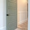 Photo Square frame House interior with transom window above the gray door with black door knob