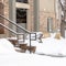 Photo Square Yard and stone stairs covered with snow at the residential building entrance