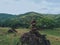 Photo of stack balanced stone at the peak of Maddo Hill, Barru, South Sulawesi, Indonesia with a beautiful landscape at noon.