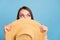 Photo of staring brown hairdo young lady hold hat look empty space wear floral blouse isolated on blue color background