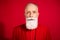 Photo of strict grey old man wear red suit isolated on red color background