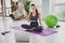 Photo of strong charming young girl dressed sport suit recording video yoga lesson waving arm smiling indoors house home