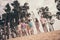 Photo of student tourist group people walk sand wear sunglass casual clothes nature summer seaside beach