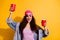 Photo of stylish lady holding red cups with beer in hands chilling with friends wear casual clothes isolated yellow