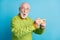 Photo of surprised grandfather hold telephone amazed face wear eyeglasses green sweater isolated blue color background