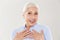 Photo of surprised old lady with hands on her chest, looking at