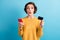Photo of surprised pretty young lady holding credit card telephone prepare pay wear yellow sweater isolated blue color