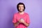 Photo of sweet cute young man wear pink t-shirt typing modern device isolated violet color background