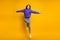 Photo of sweet funky young lady dressed violet sweater jumping hands arms sides isolated yellow color background