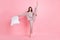 Photo of sweet shiny young lady dotted nightwear holding pillow dancing rising leg isolated pink color background