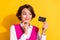 Photo of sweet tricky young lady wear pink suit holding looking bank card finger chin isolated yellow color background