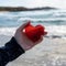 Photo Symbolic gesture Womans hand holds red heart by seashore