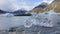 This photo is taken in Mount Cook Glacier in Zealand. A hand stretches out to hold a piece of ice. The ice is crystal clear. It