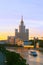 Photo of a tall building standing on the bank of the Moskva River at sunset
