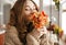 Photo of tender woman in sweater smelling beautiful flower with