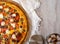In the photo there is a part of pizza with garnished cheese, tomatoes, olives. Appetizing golden brown crust. Beautiful white