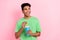 Photo of thoughtful funky man dressed green t-shirt drinking soda looking empty space isolated pink color background