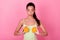 Photo of thoughtful sweet girl dressed yellow sarafan looking holding orange slices breast isolated pink color