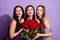 Photo of three romantic ladies hold roses lips blow air kiss wear dresses isolated violet color background