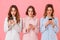 Photo of three serious young women 20s wearing bed clothing comm