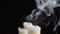 Photo of three smouldering candles on black background